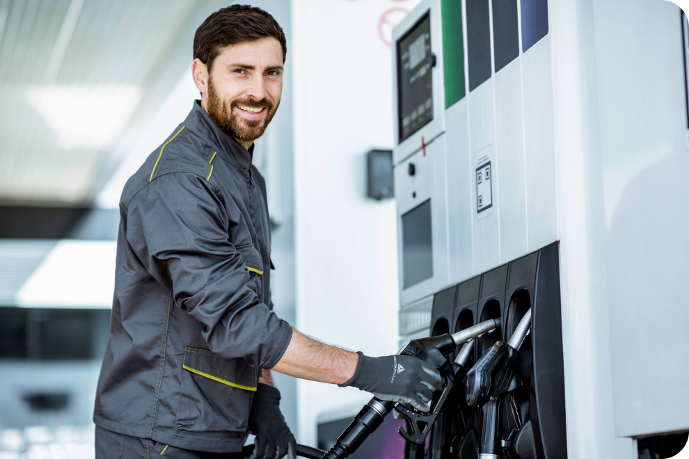 Gas Station worker holding a fuel line to refuel the car.
