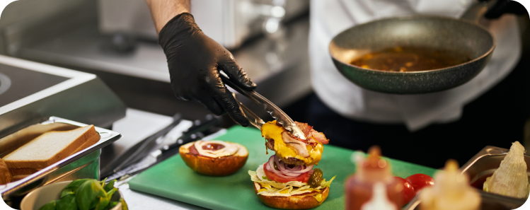 person serving a burger in a kitchen